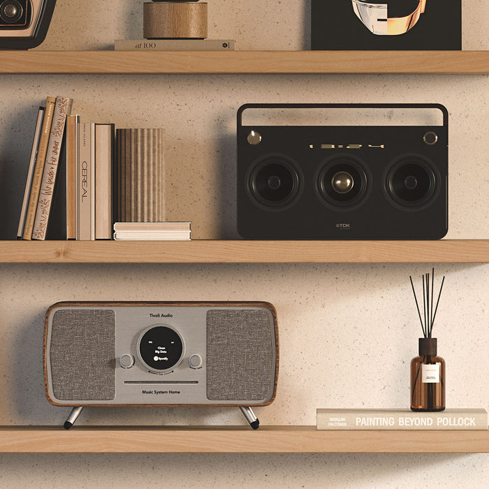 Aksel Alder Floating Shelf with minimalist wood floating shelves displaying books, audio speakers, and decor items.
