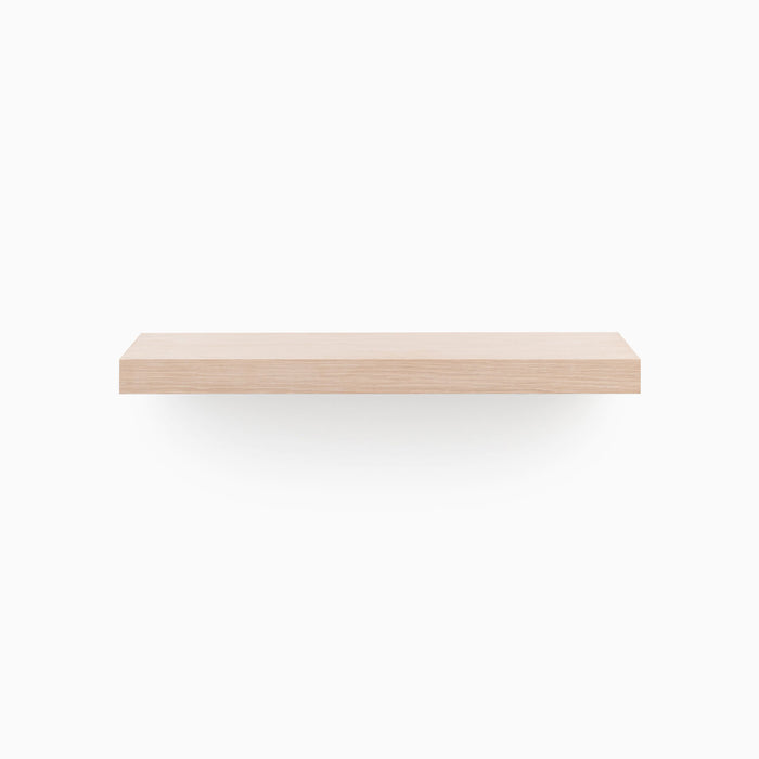 A minimalist Aksel Glazed White Oak Floating Shelf mounted on a white wall for sleek wall display.