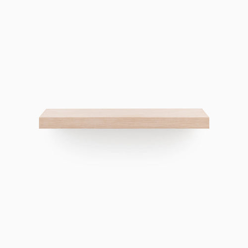 A minimalist Aksel Glazed White Oak Floating Shelf mounted on a white wall for sleek wall display.