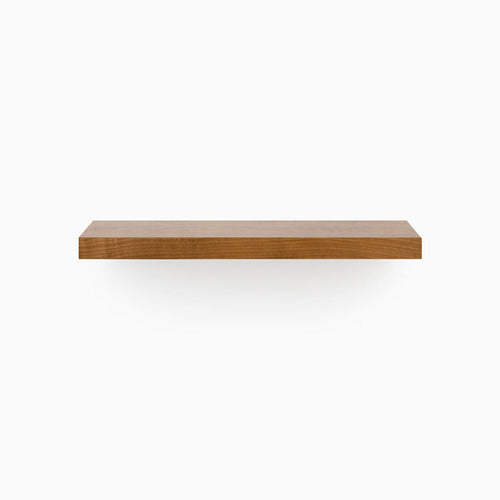 A minimalist Aksel Nutmeg Floating Shelf in warm wood tone creating functional wall display space.