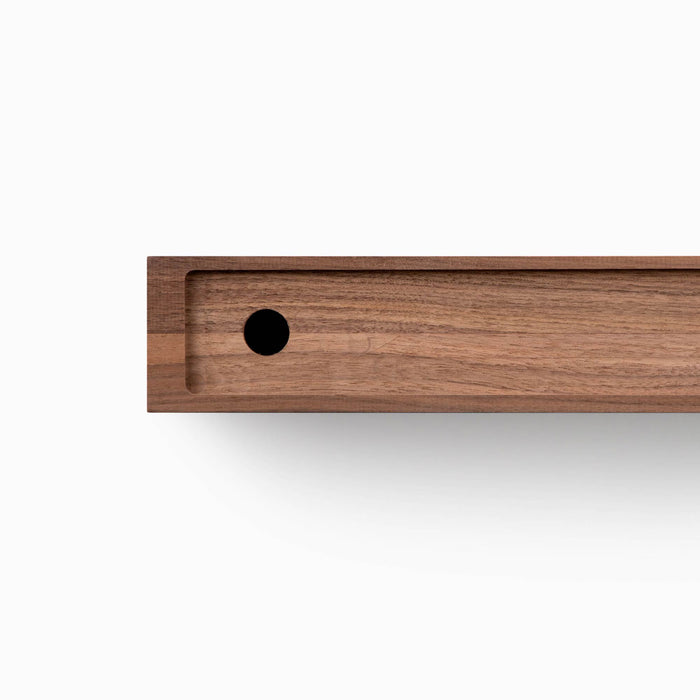 Aksel Unfinished Walnut Floating Shelf showing smooth wood grain and drilled hole for floating shelf hardware installation