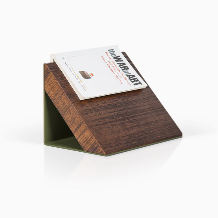 Three-quarter view of book holder with solid alder in rough nutmeg finish and forest green steel base