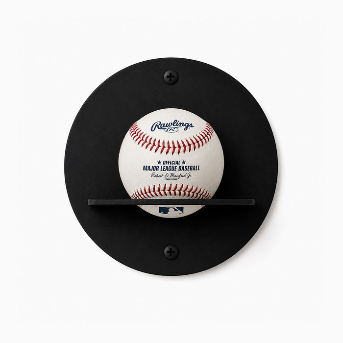 Change Up Baseball Display Shelf in matte black steel with a minimalist round backplate and a slim ledge holding a Major League Baseball, designed for clean wall mounting to honor and showcase treasured baseballs.