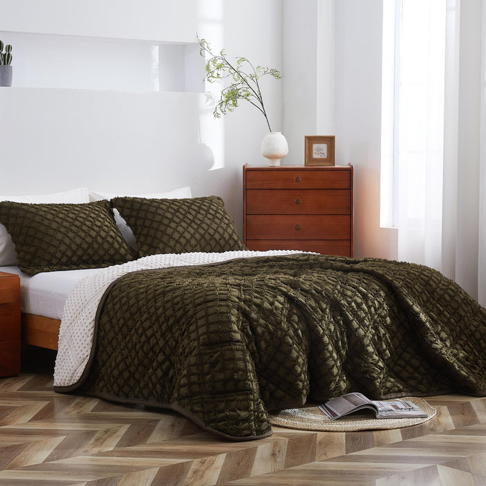 Bedroom with a bed covered in a green quilt, wooden nightstands, and a lamp.