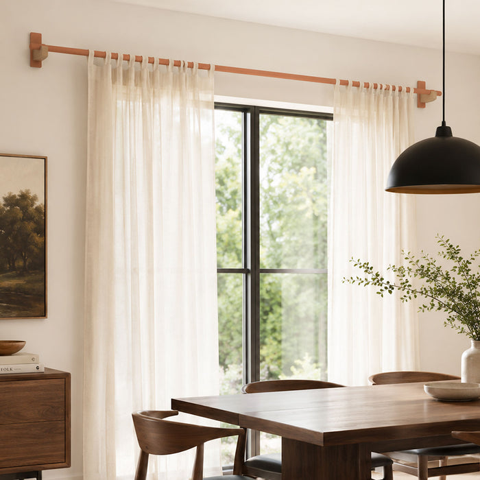 Light wooden Draper Curtain Rod System with sheer cream curtains in a minimalist dining room featuring solid hardwood furniture and natural light.