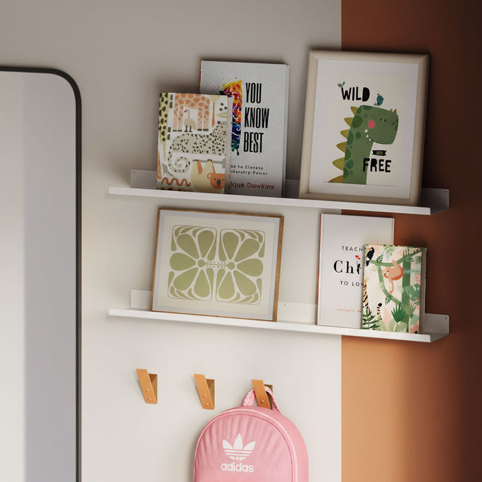 Fat Lippie Picture Ledge (3" Depth) in matte white steel floating shelf holding framed art and books on split-tone wall