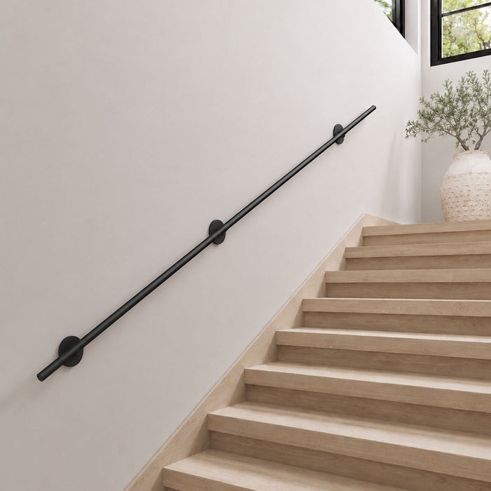 Grip Stair Rail in matte black metal, installed along minimalist staircase wall for functional support and safety.