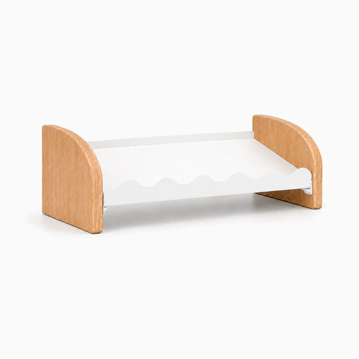 Kiddie Kicks Shoe Rack featuring solid white oak side legs and a powder-coated steel shelf with playful wave-shaped grooves for organizing small children’s footwear.