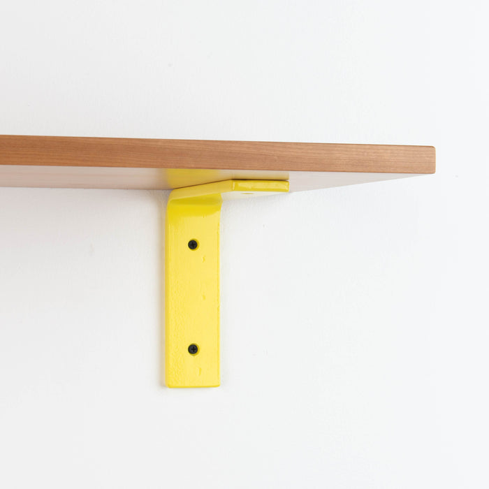 Leif Cherry Wall Shelf with solid cherry wood and bright yellow metal hardware for vibrant floating shelf support