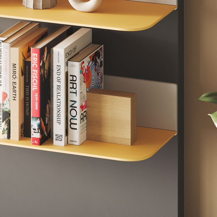 Image of a wall with one orange tromso radius shelf, holding books and vases. One Maggie Square (white oak finish) bookend positioned holding the books.