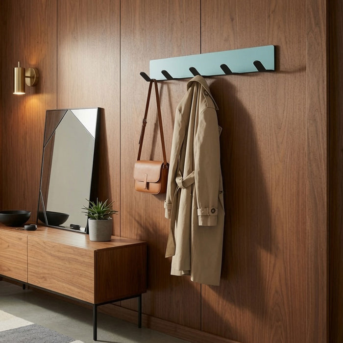 Of Course Wall Hook mounted on a wooden wall holding a beige coat and leather bag, next to a modern wooden sideboard with a geometric mirror and small plant, showcasing minimalist, functional wall hooks for organized living spaces.