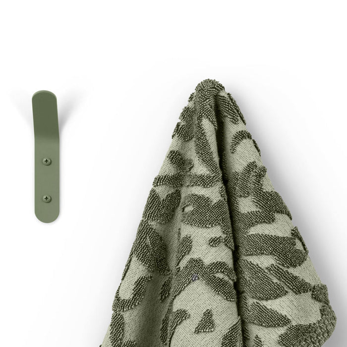 Popsicle Wall Hook in muted green steel with smooth edges and two mounting screws holding a textured towel by Shelfology
