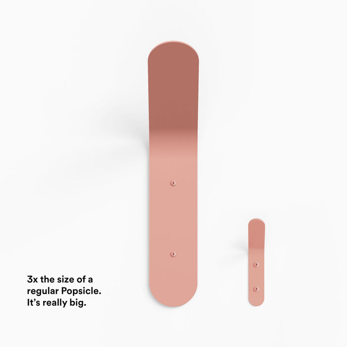 Really Big Popsicle Wall Hook in matte rose steel shown in size comparison highlighting its oversized functional design