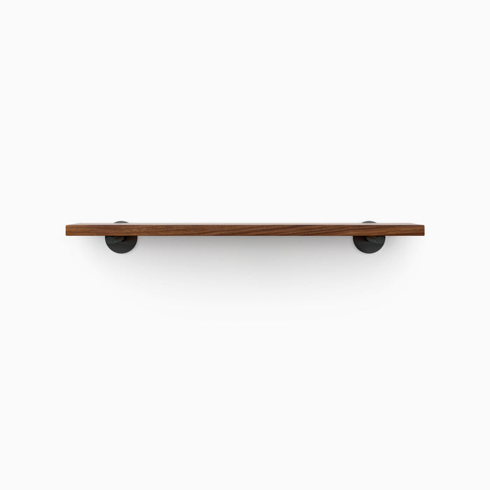 Roderick Walnut Wall Shelf with smooth walnut glue-up and round black metal floating shelf brackets for clean wall display