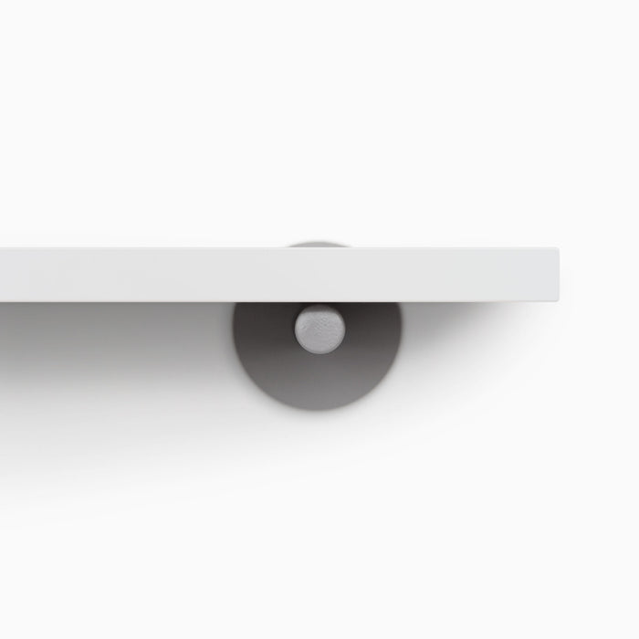 Roderick White Wall Shelf featuring smooth white hardwood and discreet arsenic gray metal floating shelf brackets for sleek display