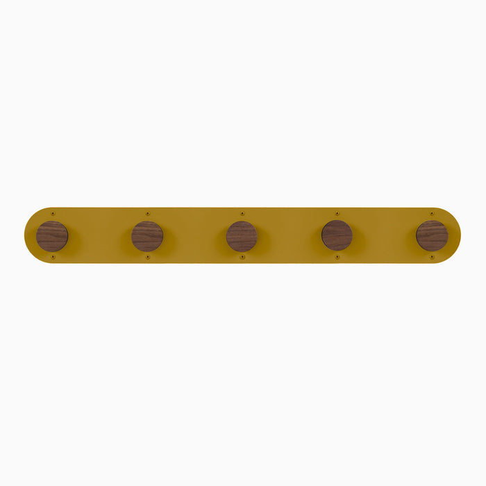 Runda Coat Rack 5 with five walnut hardwood pegs on a mustard steel base for versatile wall hooks and organization