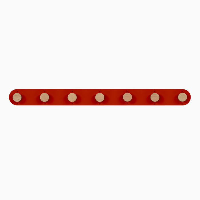 Runda Coat Rack 7 with seven solid hardwood pegs on a vibrant red steel base for versatile wall hooks and organization