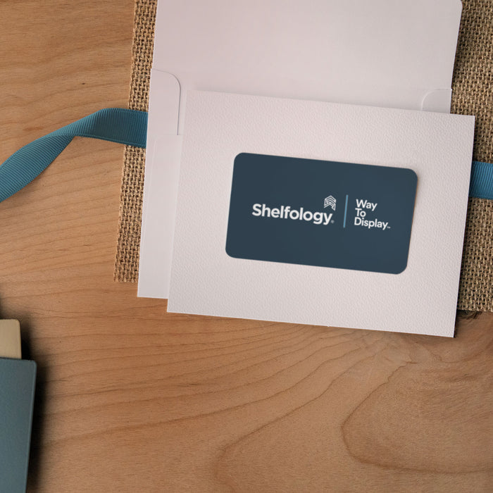 Shelfology eGift Card in white envelope with blue ribbon on wood surface for gifting organization solutions