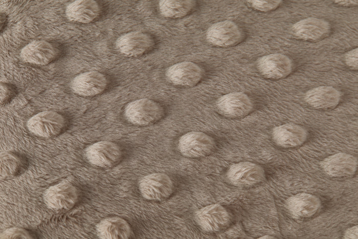 Close-up of a textured taupe fabric with raised dots