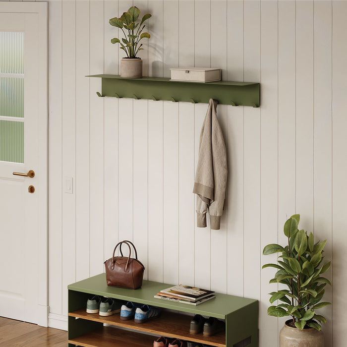 Splendid Shelf + Coat Hooks in olive green mounted on white shiplap wall holding a small plant and box with a beige coat hanging, above a matching shoe bench.
