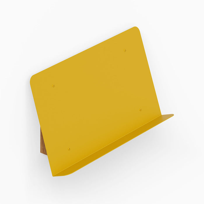 The Edit Book +Magazine Display in mustard yellow metal with solid hardwood accents, designed for stylish and functional wall organization.