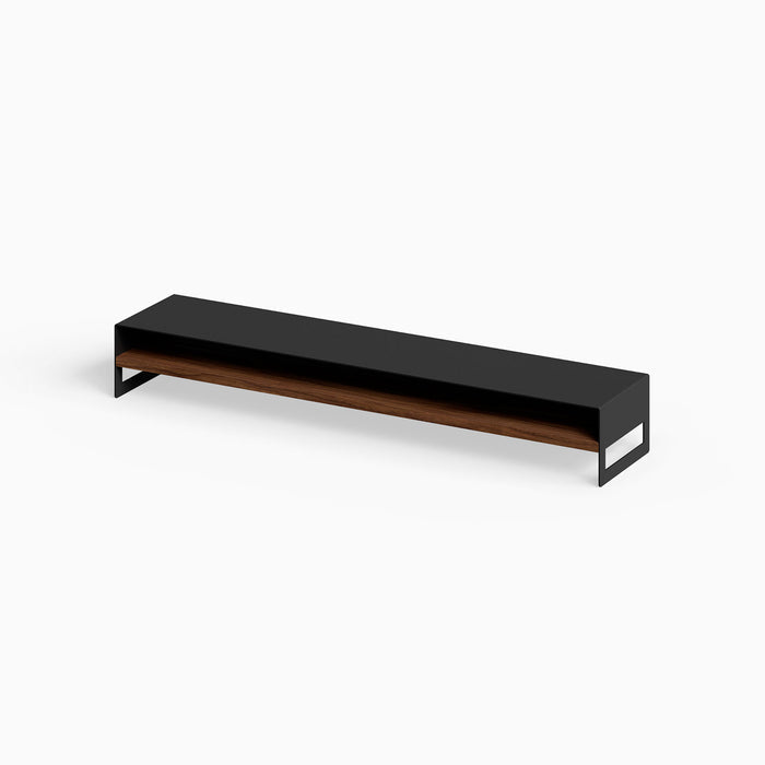 Woz Monitor Stand featuring minimalist black steel frame with walnut wood shelf, designed for functional workspace organization and display.