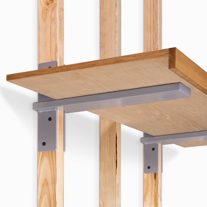 Yuri XD Floating Desk Bracket (Powder Coated) in matte steel finish supporting a solid wood shelf mounted on vertical wooden studs for sturdy wall shelving.